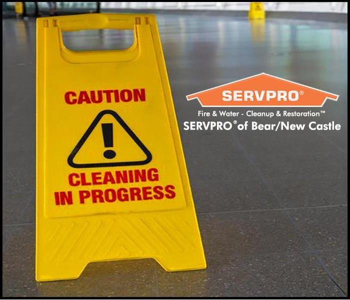 Image of a freshly cleaned tile floor with a yellow sign that reads "Caution Cleaning in Progress"
