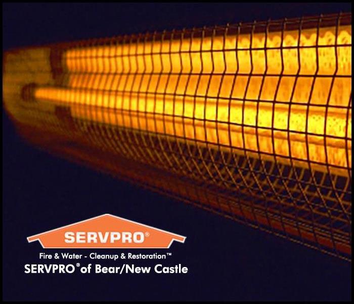 Close up of a space heater's grill, it's on and glowing orange