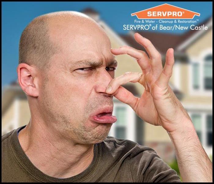 Man holding his nose outside of his house