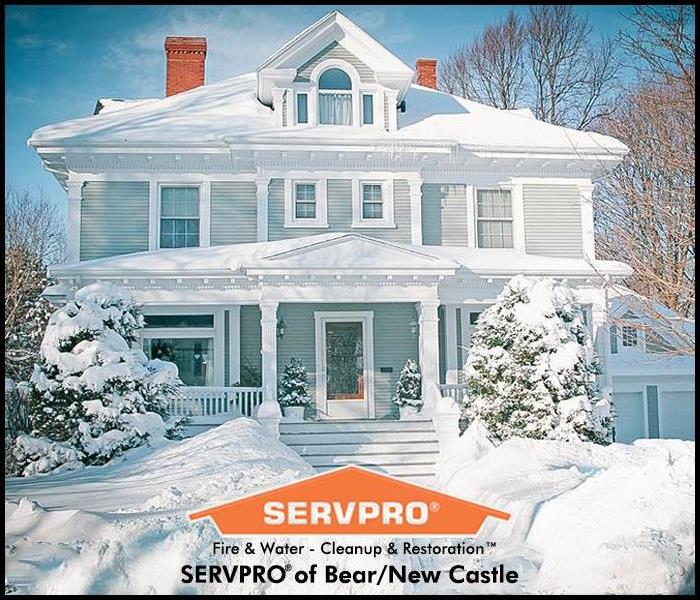 Front of 2 story home covered in snow with SERVPRO logo