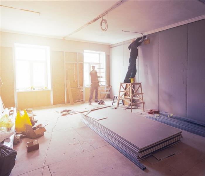 Workers are installing plasterboard (drywall) for gypsum walls in apartment is under construction, remodeling, renovation, ex